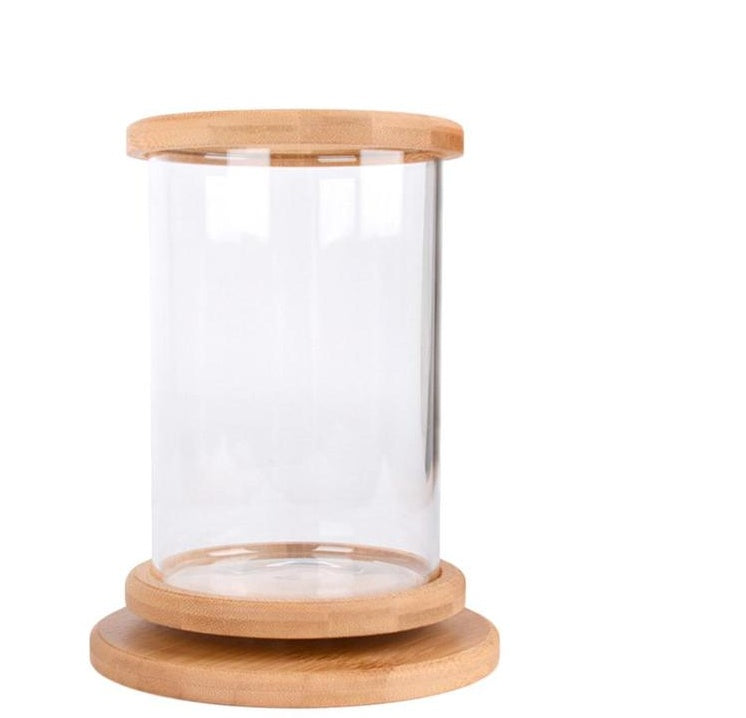 Glass jar with wooden lid and base on a white background