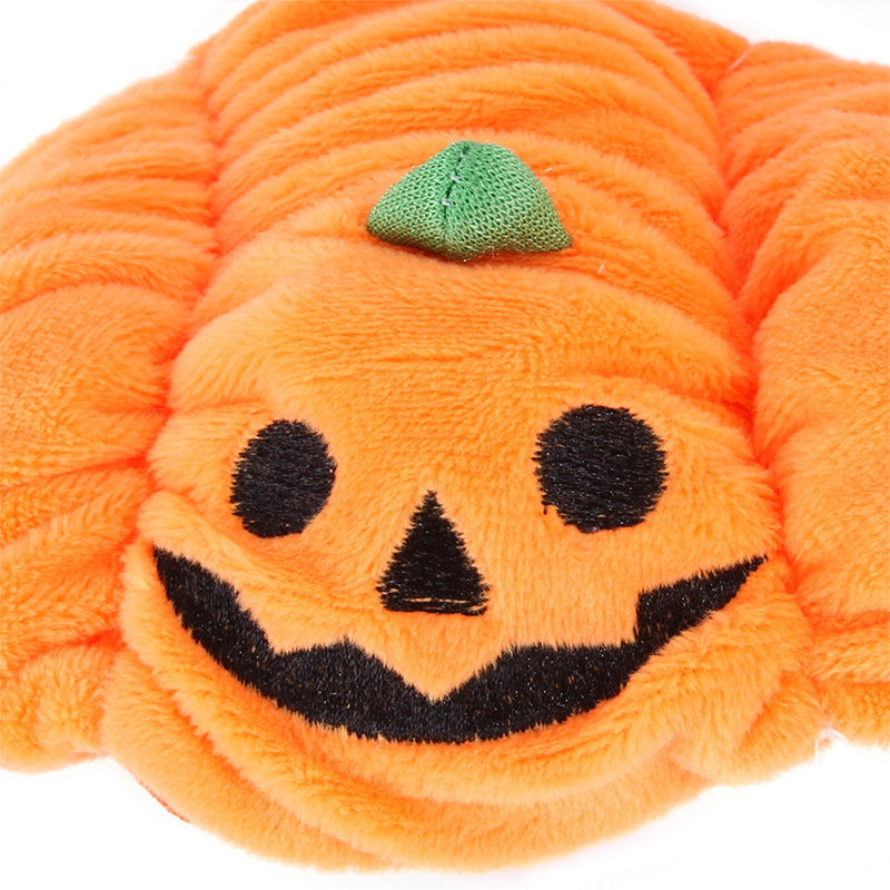 Plush pumpkin toy with a smiling face on a white background